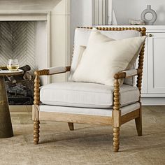 a white chair sitting next to a fireplace in a living room