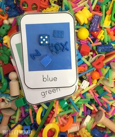 a pile of colorful plastic toys with the words blue and green on them, surrounded by letters