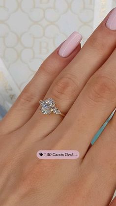 a woman's hand with pink manicured nails and a diamond ring