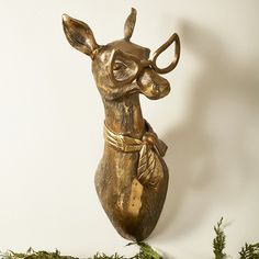 a brass statue of a deer with horns on it's back