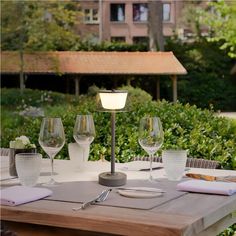 the table is set with wine glasses and place settings for two people to sit at