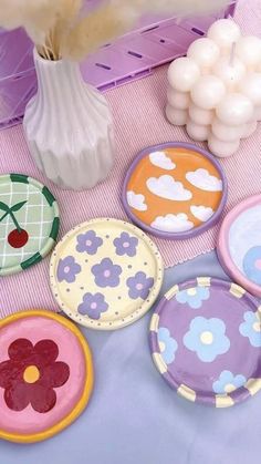 there are many plates on the table and one is decorated with flowers, clouds and hearts