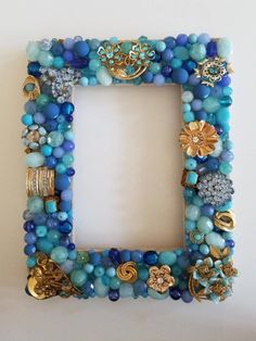 a blue and gold beaded frame is shown with beads on the bottom, along with other jewelry