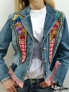 a woman wearing a jean jacket with colorful patches on it