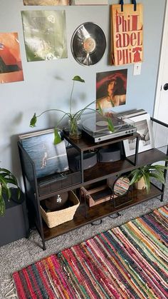 a living room with a rug and various pictures on the wall, including a record player