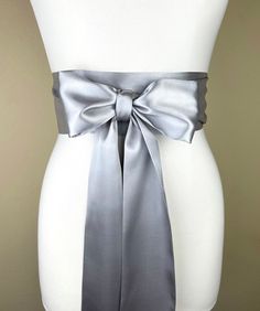 "Bright Silver Sash, Silver Satin Sash  Silver Obi Wrap Belt  Long Silver Sash Belt  Wedding Accessories  Silver Wedding Sash  Satin Swank  Make this Satin Swank® reversible waist sash the perfect finishing touch for your wedding, bridesmaid, or special occasion dress, or just the right piece to add instant polish to your dress or top.  This extra long version is 3.5 inches wide, 120 inches long, and will wrap around most waist sizes two times with a generous length remaining to tie in a bow or a simple knot with long-hanging tails.  Tie in front or in back.   Those with smaller waists may be able to wrap this extra-long sash around three times.  Position the waist wrap up high (just under the bustline) for a flattering, empire-waist effect. Luxury charmeuse satin in bright silver on both Wedding Sash With Tie Back, Elegant Satin Sash With Tie Back, Satin Ribbon Bridal Belt For Parties, Elegant Bridal Belt With Satin Bow For Bridesmaid, Satin Bridal Belt For Bridesmaids, Wedding Satin Tie Back Sash, Silver Fitted Sash For Party, Fitted Silver Sash For Party, Wedding Bridal Belt With Sashes In Satin