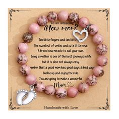 a pink beaded bracelet with a silver heart charm and an inscription on the front