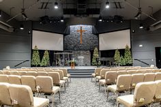 an empty church with rows of chairs and a cross on the wall