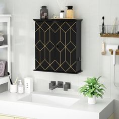 a bathroom with a black cabinet and white counter top next to a plant in a vase