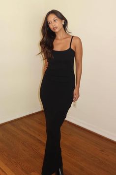 a woman in a black dress posing for the camera