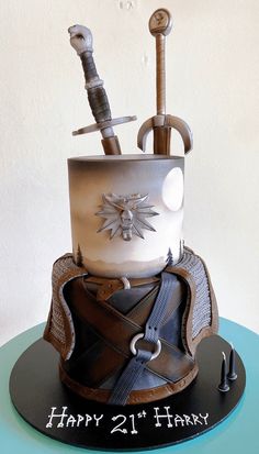 a birthday cake made to look like a knight's helmet with two swords sticking out of it