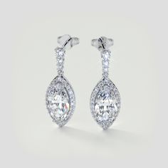 Stun her today with this exquisite set of earrings. Featuring our simulated diamonds, this earring set is shining with integrity. A beautiful pave halo emphasizes each quality center stone placed within a 4-prong setting. An ideal gesture for that special someone in your life.  Marquise Cut Drop Style Slider Bail Earrings Center Stone: 3CT Each Total Carat Weight: 6.89CTW Stone Clarity: VVS-1 Available in: 925 Sterling Silver Model: ER2504-WH-SL Tiffany Engagement Ring, Halo Earrings, Matching Wedding Bands, Gold Models, Halo Pendant, Lab Grown Diamonds Engagement, Free Earrings, Halo Engagement Rings, Solitaire Pendant