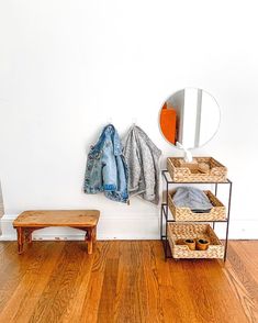 a wooden bench sitting on top of a hard wood floor next to a white wall