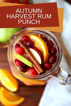 an autumn harvest punch in a mason jar with apples, cranberries and cinnamon sticks