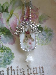 This Vintage China has been recycled into a Pendant with a Bunny Nibbling the Roses The Rose Nibbler.  Includes a 30" ball chain necklace.  A custom-made frame surrounds this vintage piece of china with  my small signature scallops.  An ornate metal piece adorns the top and a glass flower dangles at the bottom.    Measures 2" x  1 3/4". This is for the single pictured charm only.  Picture props and multiple charms not included. Shipping is only $4.95 for first charm and free on any additional ch Broken China Crafts, Christmas Gift Inspiration, China Crafts, Picture Props, Shabby Chic Jewelry, Coquille Saint Jacques, Broken China Jewelry, China Jewelry, Filigree Jewelry