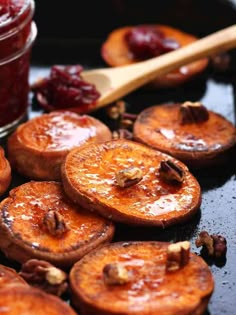 some food that is sitting on a table next to a jar of jam and spoon