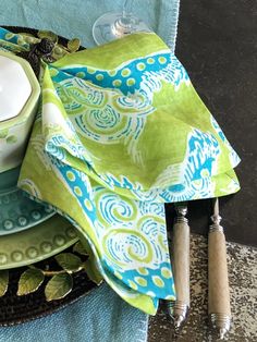 a green and blue place setting on a table