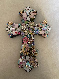 a cross made out of many different types of buttons