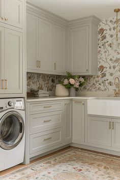 a washer and dryer in a kitchen with floral wallpaper on the walls