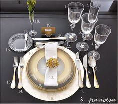 the table is set with silver and gold plates, forks, knives, and napkins