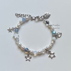 "A sweet handmade bracelet ✿ Made with freshwater pearls, Quartz, mother of Pearl, glass, glass crystal, and metal accents ✿ Pearlescent white, icy blue, iridescent clear, sky blue, frosted clear, black, and silver ✿ The bracelet has an additional 1-1.5\" of extension chain I paired this bracelet with the Mystic Pearl bracelet which is also available in my shop!" Silver And Blue Bracelet, Handmade White Pearl Charm Bracelet, Handmade Pearl Crystal Bracelet In Silver, Handmade Silver Pearl Crystal Bracelet, Handmade White Pearl Crystal Bracelet, Mother Of Pearl Bracelet, Bracelets Design, Diy Bracelet Designs, The Mystic