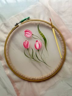 some pink flowers are sitting on a white table cloth and next to a pair of scissors