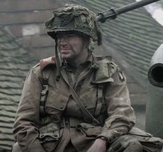 a man in uniform sitting on top of a tank