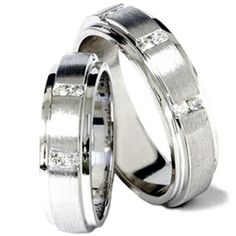 two white gold wedding rings with princess cut diamonds on each side and channel set in the middle