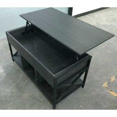 a black table with an open drawer on it's side in a warehouse or office