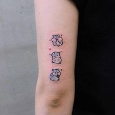 a woman's arm with three small tattoos on it, including two hippos