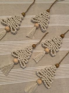 four crocheted ornaments with tassels and beads on a tablecloth background