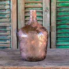 a brown vase sitting on top of a wooden table