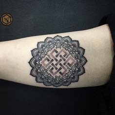 a woman's arm with an intricate tattoo design on the left side of her arm