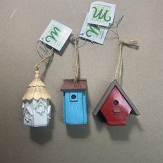 three small birdhouses with price tags hanging from them