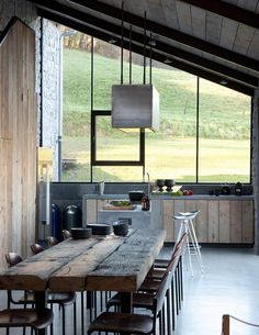 a large wooden table sitting in the middle of a kitchen next to an open window