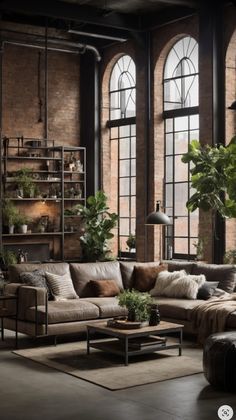 a living room filled with lots of furniture next to large windows and potted plants