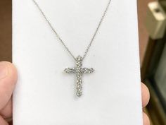 "The item is a 14 k white gold diamond cross that measures 21 x 16 millimeters. The cross consists of 11 round lab grown diamonds. The diamonds have a \"F\" color and an \"SI 1\" clarity grading. The diamonds weigh 0.98 carats. The chain is a 14 k white gold rope chain with  spring ring catch. The chain is adjustable and can be worn at 18 or 20 inches long. This item weighs 2.190 grams. I will provide a pendant box." Anniversary Diamond Cross Necklace Vvs Clarity, Diamond Cross Necklace With Vvs Clarity For Anniversary, Anniversary Diamond Cross Necklace With Vvs Clarity, White Gold Diamond Cross Necklace For Wedding, Brilliant Cut Round White Gold Cross Necklace, Silver Diamond Round Cross Necklace, Silver Diamond Cross Pendant Necklace, Diamond Cut White Gold Cross Necklace, Formal Diamond Cross Necklace With Brilliant Cut