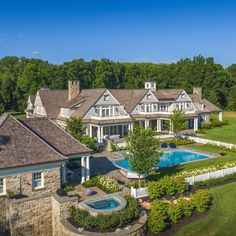 an aerial view of a large home with a pool in the front yard and landscaping around it