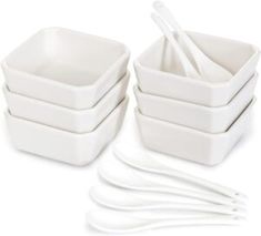 a set of four white square bowls and forks