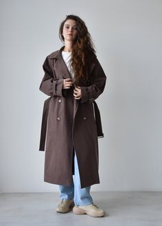 Taupe Trench coat for women, Double breasted oversize trench coat for women, Classic cotton long coat for fall and spring A classic and timeless trench coat is a great addition to any wardrobe. It has ultimate versatility and pairs well with others. Our cotton taupe trench is a slightly oversized classic cut with a vintage touch to it. Perfect for the fall-spring season. ■ color: taupe View shop for other color options ■ material: Outer: 100% Cotton Lining: 100% Viscose ■ style: - relaxed fit - lined - double-breasted - classic length - belted - six-button front closure - regulated cuffs - two pockets ■ fit: The model is 172cm/ 5′ 8″ tall and wears a size 1 ■ sizing: Size 1 fits for height 158-175 cm / 5′ 2″ - 5′ 9″, XS, S, M. Size 2 fits for height 175-185 cm / 5′ 9″ - 6′ 1″, S, M, L. ■ t Chic Long Cotton Coat, Cotton Long Coat With Double Button Closure, Belted Cotton Outerwear For Winter, Oversized Double-breasted Solid Outerwear, Cotton Long Coat, Oversized Belted Cotton Outerwear, Oversize Trench Coat, Coat For Fall, Brown Trench Coat