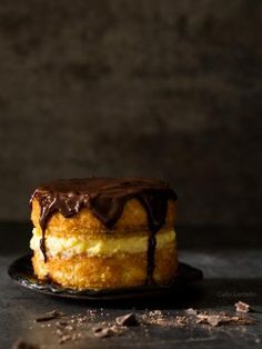 a chocolate covered cake sitting on top of a black plate