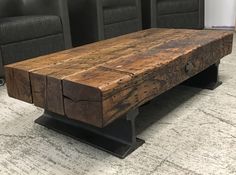 a wooden table sitting on top of a carpeted floor next to two black chairs