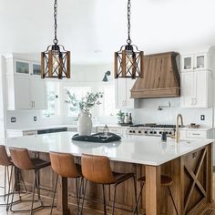 a large kitchen with an island and wooden chairs