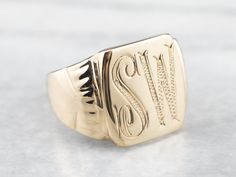 "This vintage signet ring has a beautiful monogram! Finally engraved accents and a stylish script provide a great focal point for this statement ring. We've left the original engraving on the inside as well, \"1955\", as a sweet reminder of the ring's history. Metal: 14K Yellow Gold Top Measurements: 14 x 15 mm, Rectangle Monogram: \"SW\" in Bold Font Ring Size: 9 Marks: \"1955 14K ME\" Stamped on the inside band SKU #: AF72NLMU Each piece has been identified and graded by a Graduate Gemologist Luxury Gold Square Cut Signet Ring, Luxury Art Deco Signet Ring For Anniversary, Luxury Antique Signet Ring Stamped 925, Luxury Oval Art Deco Signet Ring, Signet Ring Men, Monogram Ring, Signet Rings, Top Measurements, Personalized Ring