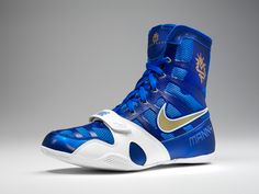 a pair of blue and white basketball shoes on a gray background with the word nike written in gold