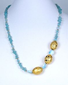 Crystal Lake Necklace in 23-Karat Gold Leaf on Three Lava Stones, Apatite, Larimar, and 24-Karat Gold-Plate Over PyriteI've hand-gilded unique lava stone with mesmerizing 23-Karat gold leaf, designing with blue aqua apatite, sparkly faceted larimar, nugget-like 24-Karat gold-plated pyrite, smooth 14-Karat gold-filled toggle clasp, and my signature tag. This brooch-like necklace measures 20" and is designed to hang asymmetrically.Apatite is found in a number of places in the world, including Myan Gold Amazonite Gemstone Necklaces, Handmade Gold Amazonite Necklaces, Handmade Gold Amazonite Necklace, Gold Amazonite Gemstone Beads Jewelry, Gold Amazonite Jewelry With Gemstone Beads, Lava Jewelry, Semi Precious Gems, Crystal Lake, Places In The World