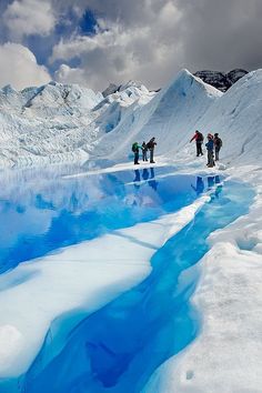 several people standing on the edge of a frozen lake