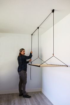 a man is hanging something from the ceiling