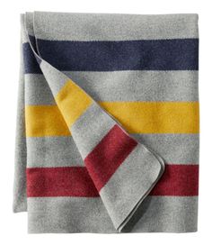 a striped blanket folded on top of a white table with red, yellow and blue stripes