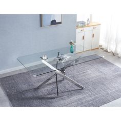 a glass table sitting on top of a gray rug